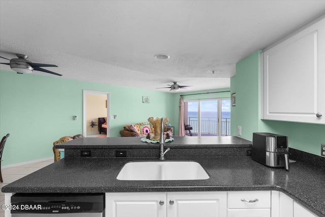 kitchen featuring white cabinets, dishwasher, a textured ceiling, sink, and light tile patterned floors