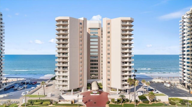 view of building exterior featuring a beach view and a water view