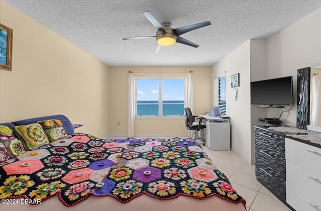 tiled bedroom featuring a textured ceiling and ceiling fan