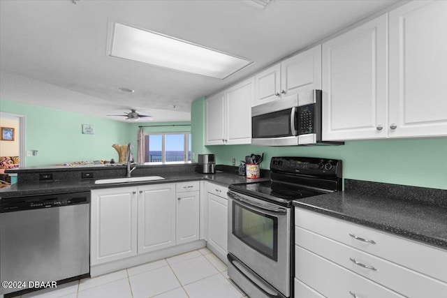 kitchen with sink, ceiling fan, light tile patterned flooring, white cabinetry, and appliances with stainless steel finishes