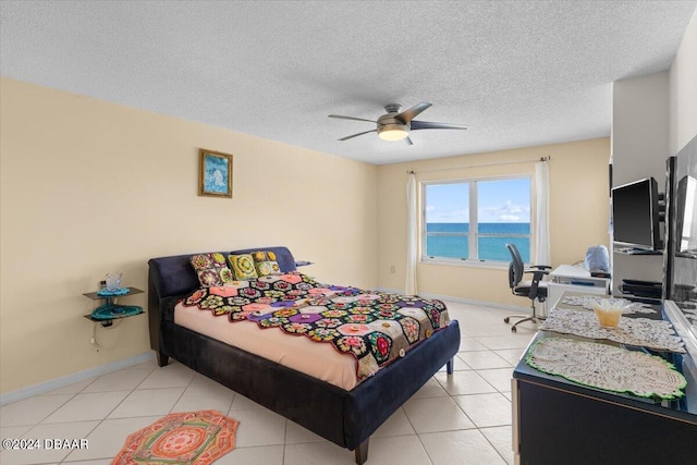 bedroom with a textured ceiling, ceiling fan, and light tile patterned floors