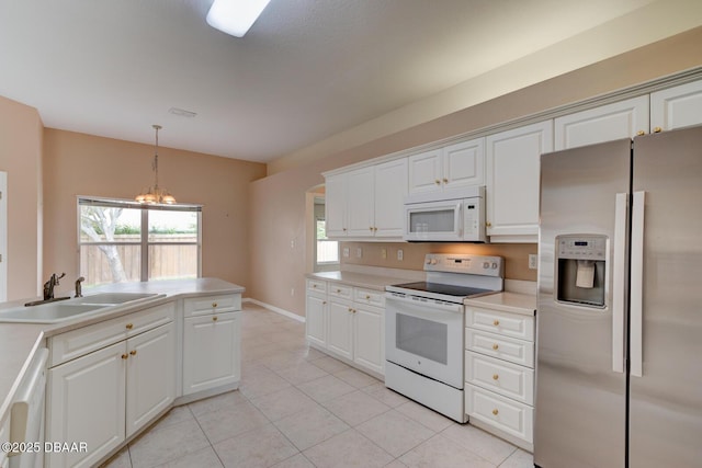 12 Sea Swallow Ter, Ormond Beach, FL 32176 - kitchen with white appliances, a chandelier, light tile patterned floors, light countertops, and white cabinetry