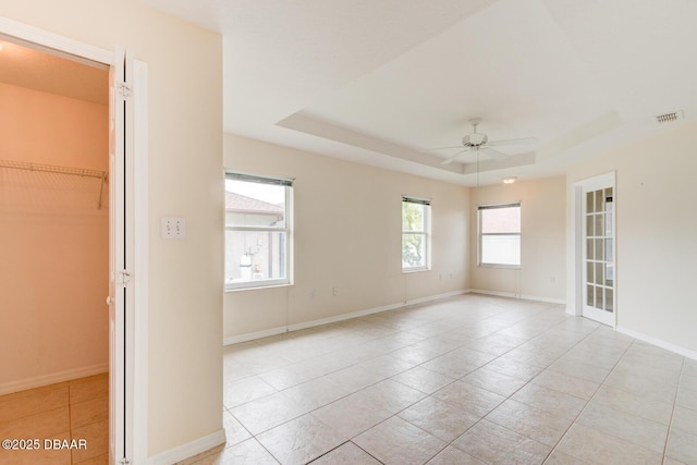 12 Sea Swallow Ter, Ormond Beach, FL 32176 - spare room featuring a ceiling fan, light tile patterned flooring, and a tray ceiling
