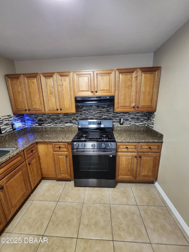 812 S Kottle Cir Unit S, Daytona Beach, FL 32114 - kitchen featuring stainless steel range with gas cooktop, under cabinet range hood, brown cabinets, backsplash, and light tile patterned floors