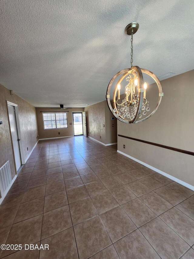 812 S Kottle Cir Unit S, Daytona Beach, FL 32114 - empty room featuring a chandelier, a textured ceiling, dark tile patterned flooring, and baseboards