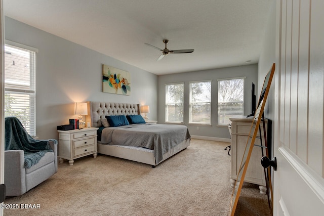 bedroom with light carpet, ceiling fan, and baseboards