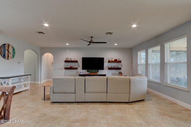 living room featuring arched walkways, ceiling fan, recessed lighting, visible vents, and baseboards