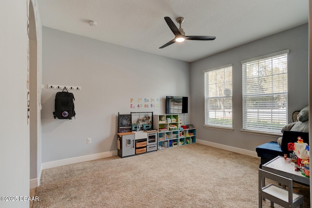 rec room with a ceiling fan, carpet flooring, a textured ceiling, and baseboards