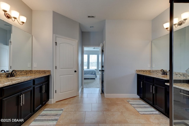 ensuite bathroom with two vanities, visible vents, ensuite bathroom, a sink, and baseboards