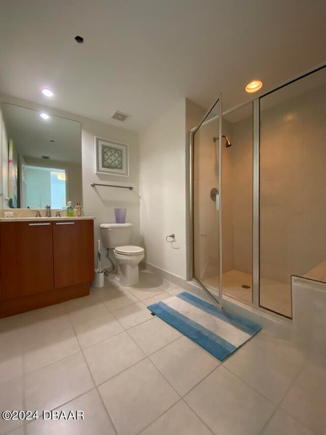 bathroom with tile patterned flooring, vanity, toilet, and a shower with shower door