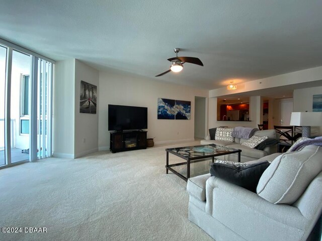 carpeted living room with ceiling fan