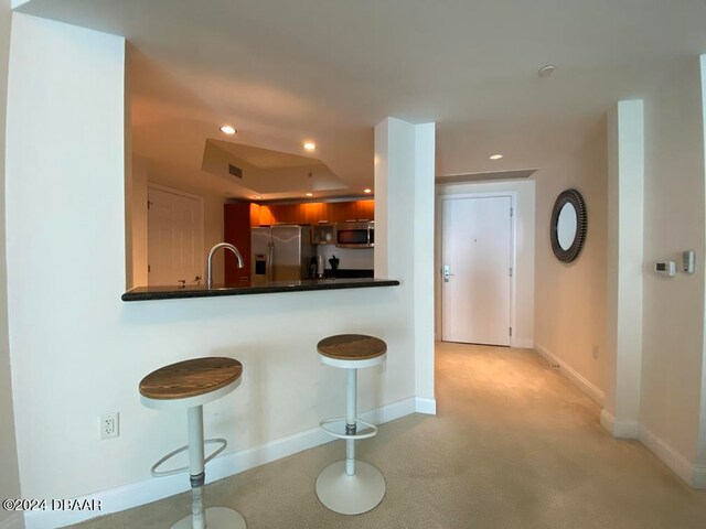 kitchen with a kitchen bar, kitchen peninsula, and stainless steel appliances