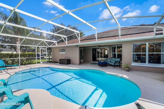 view of swimming pool featuring glass enclosure and a patio area