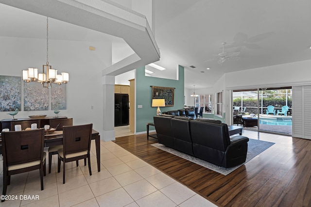 living room featuring light hardwood / wood-style floors, ceiling fan with notable chandelier, and lofted ceiling