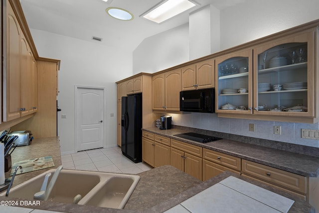 kitchen featuring sink, black appliances, tasteful backsplash, light tile patterned floors, and vaulted ceiling