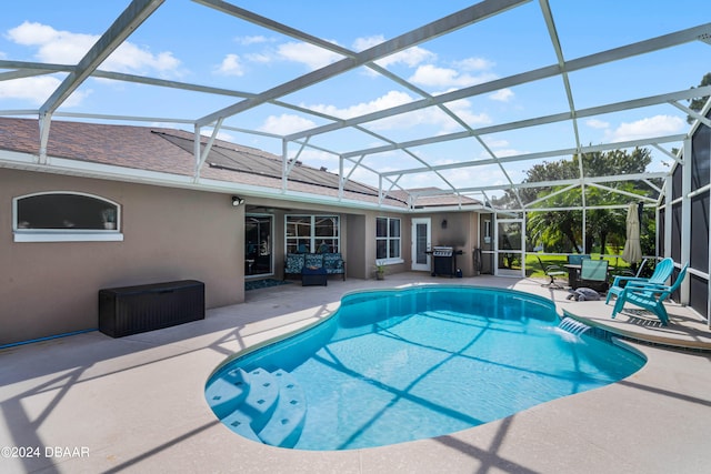 view of pool featuring a patio area, a lanai, pool water feature, and grilling area