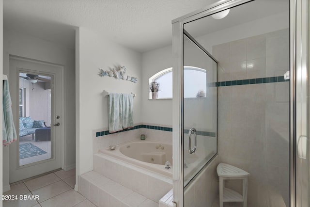 bathroom with plus walk in shower, a textured ceiling, and tile patterned floors