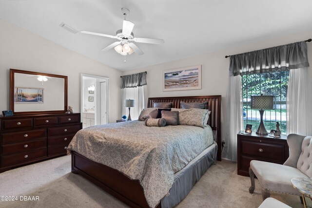 bedroom featuring ensuite bath, lofted ceiling, ceiling fan, and light colored carpet