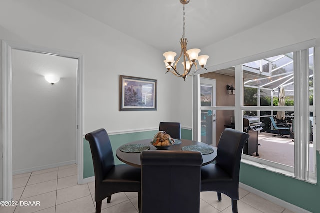 dining area featuring a notable chandelier, light tile patterned flooring, and vaulted ceiling