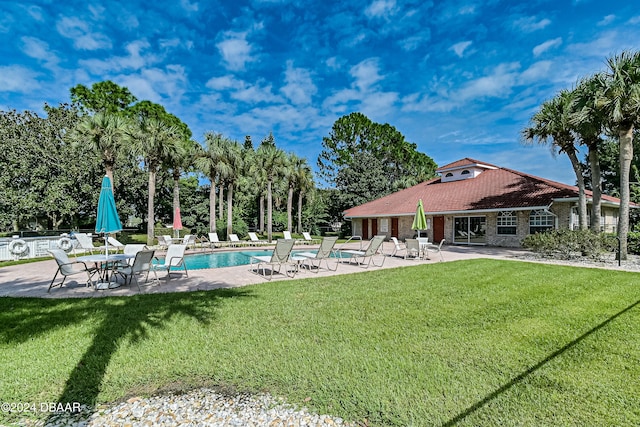 view of swimming pool featuring a lawn and a patio