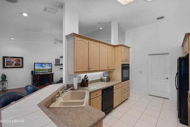 kitchen with black appliances, high vaulted ceiling, light brown cabinetry, sink, and kitchen peninsula