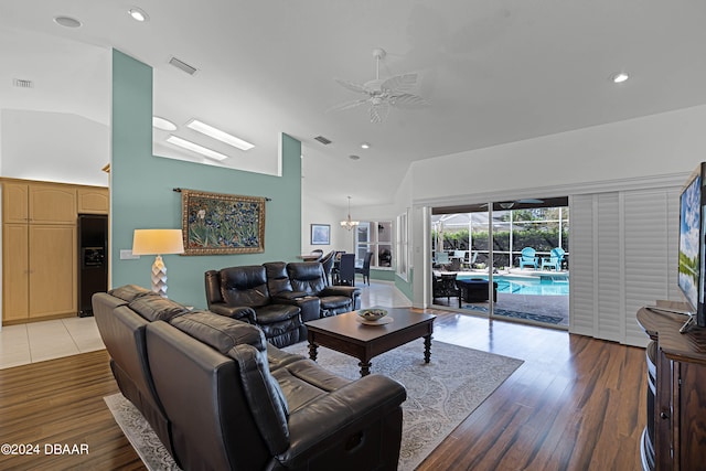 living room featuring hardwood / wood-style floors, ceiling fan, and vaulted ceiling