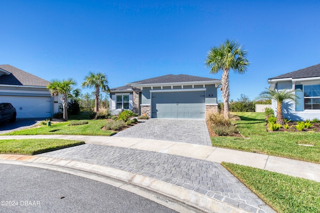 view of front of house featuring a garage, stucco siding, decorative driveway, and a front yard