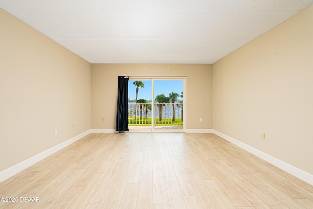 spare room with light wood finished floors and baseboards