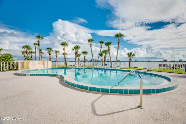 community pool featuring fence and a patio area