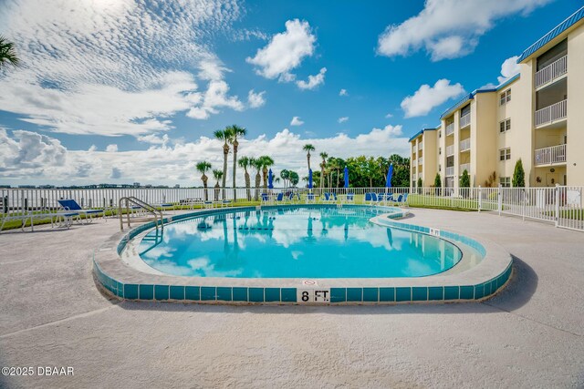community pool featuring fence and a patio area
