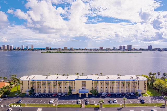 bird's eye view of a large body of water, apartment complex / building, and a skyline view