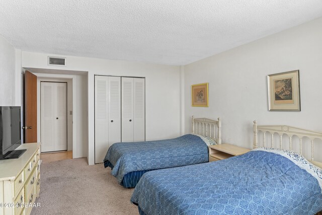 carpeted bedroom with a textured ceiling and a closet