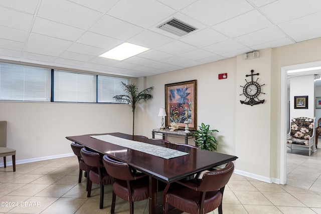 tiled dining room with a paneled ceiling