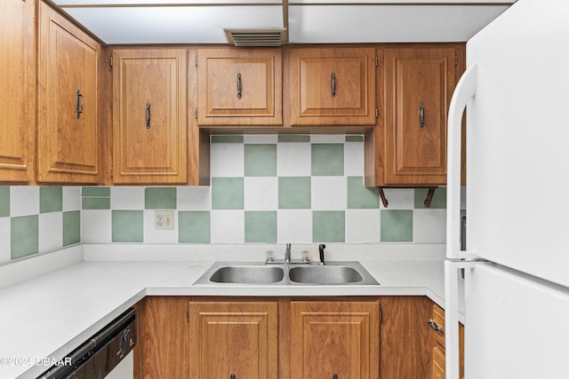 kitchen featuring dishwasher, tasteful backsplash, sink, and white fridge