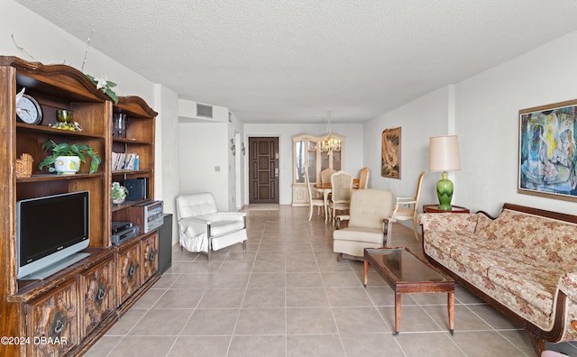 living room with a textured ceiling, a notable chandelier, and light tile patterned floors