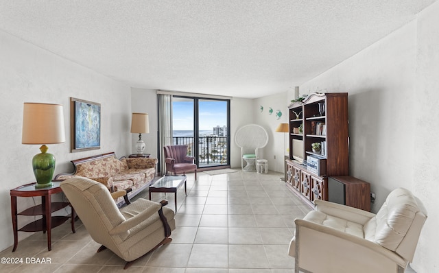 tiled living room featuring floor to ceiling windows and a textured ceiling