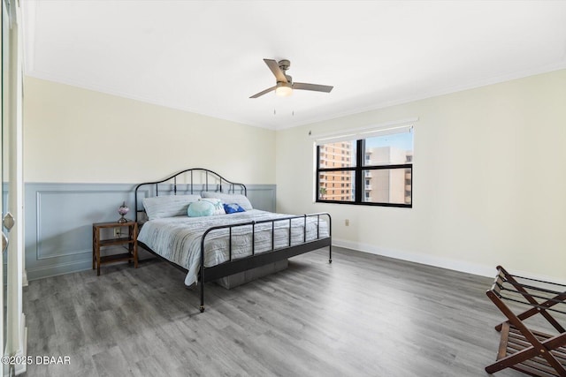 bedroom with ceiling fan, ornamental molding, and hardwood / wood-style floors