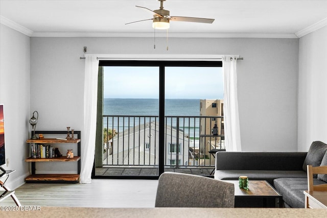 living room with a wealth of natural light, a water view, and ornamental molding