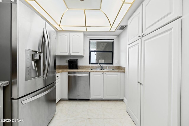 kitchen with appliances with stainless steel finishes, white cabinetry, and sink