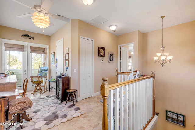 interior space with light tile patterned flooring and ceiling fan with notable chandelier