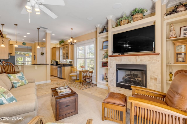 living room with a high end fireplace, ceiling fan with notable chandelier, built in features, and ornamental molding