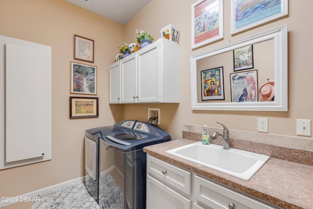 laundry area with cabinets, washer and clothes dryer, and sink