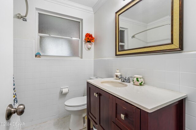 bathroom with toilet, vanity, tile walls, and ornamental molding