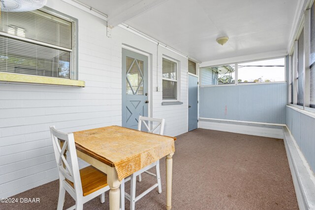 sunroom featuring beam ceiling