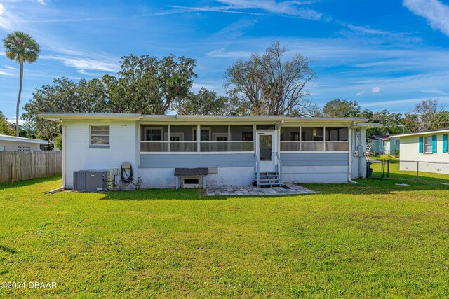 back of house featuring a yard, central AC, and a sunroom