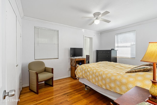 bedroom featuring hardwood / wood-style flooring, ceiling fan, and crown molding