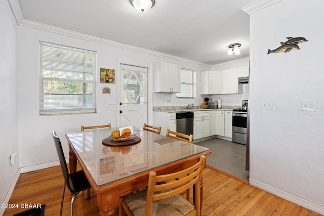 dining space featuring crown molding, light hardwood / wood-style flooring, and sink