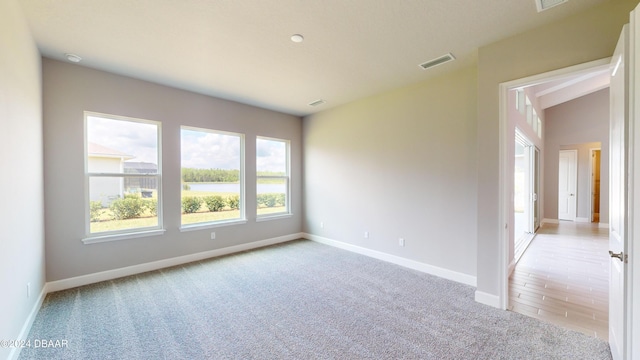 empty room featuring light carpet and lofted ceiling