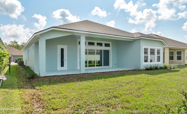 rear view of house featuring a lawn and central AC