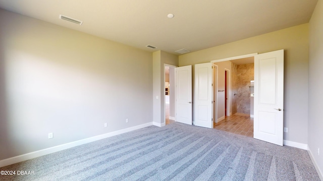 unfurnished bedroom featuring light carpet